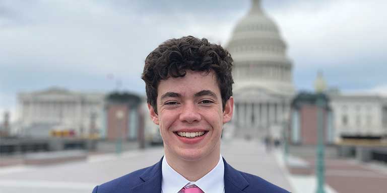 Student standing in front of the Capitol building